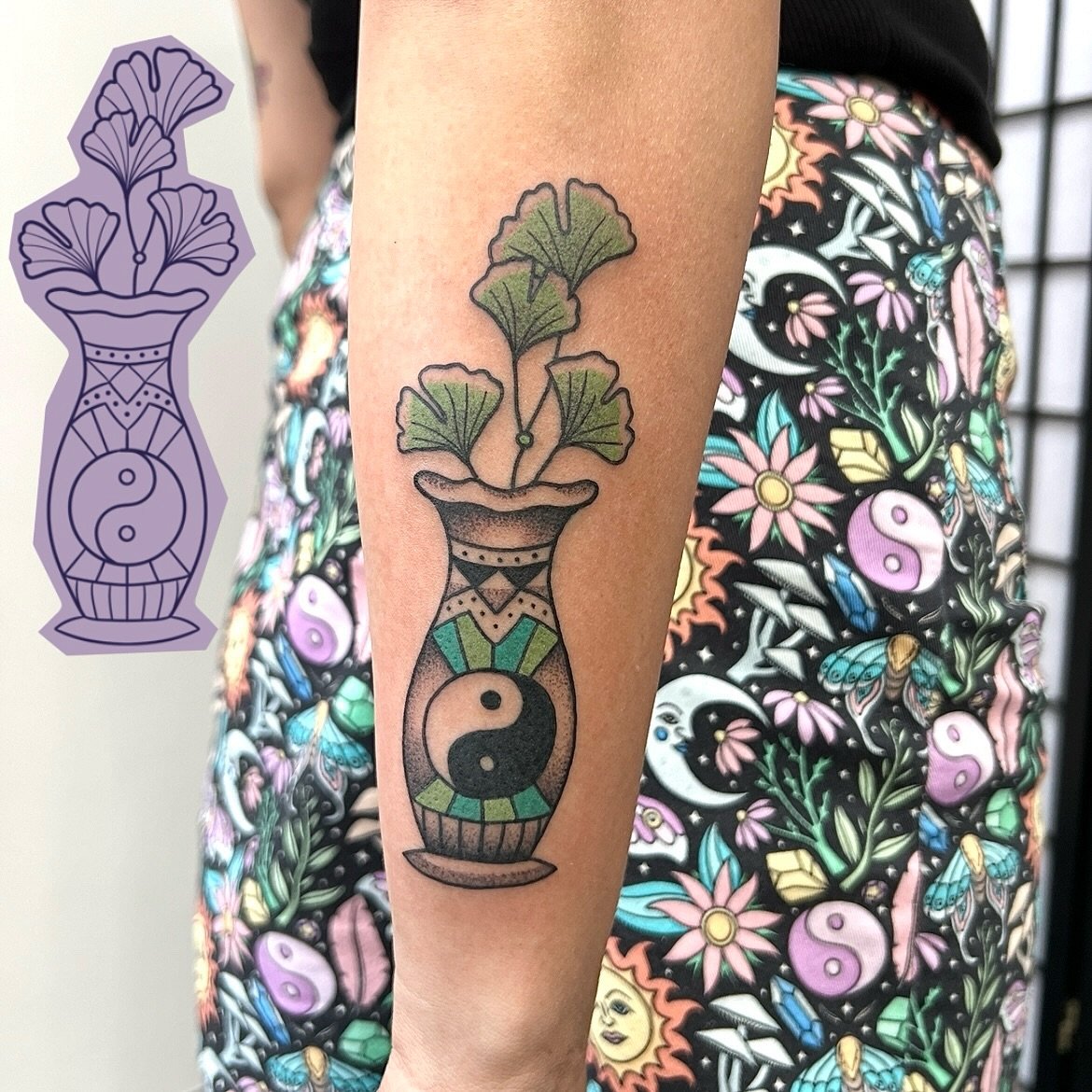 One of Gem Hawk's flash designs next to the finished tattoo, a vase of ginkgo leaves in colour